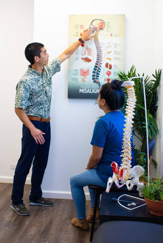 Chiropractor explaining possible effects of spinal misalignment